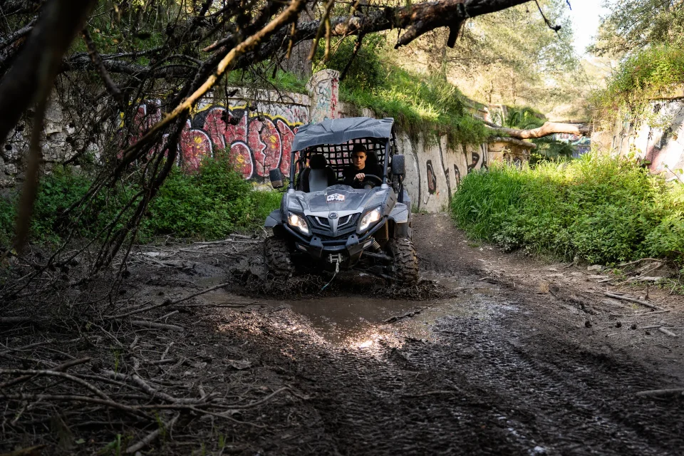 Buggy splashing through a muddy forest trail