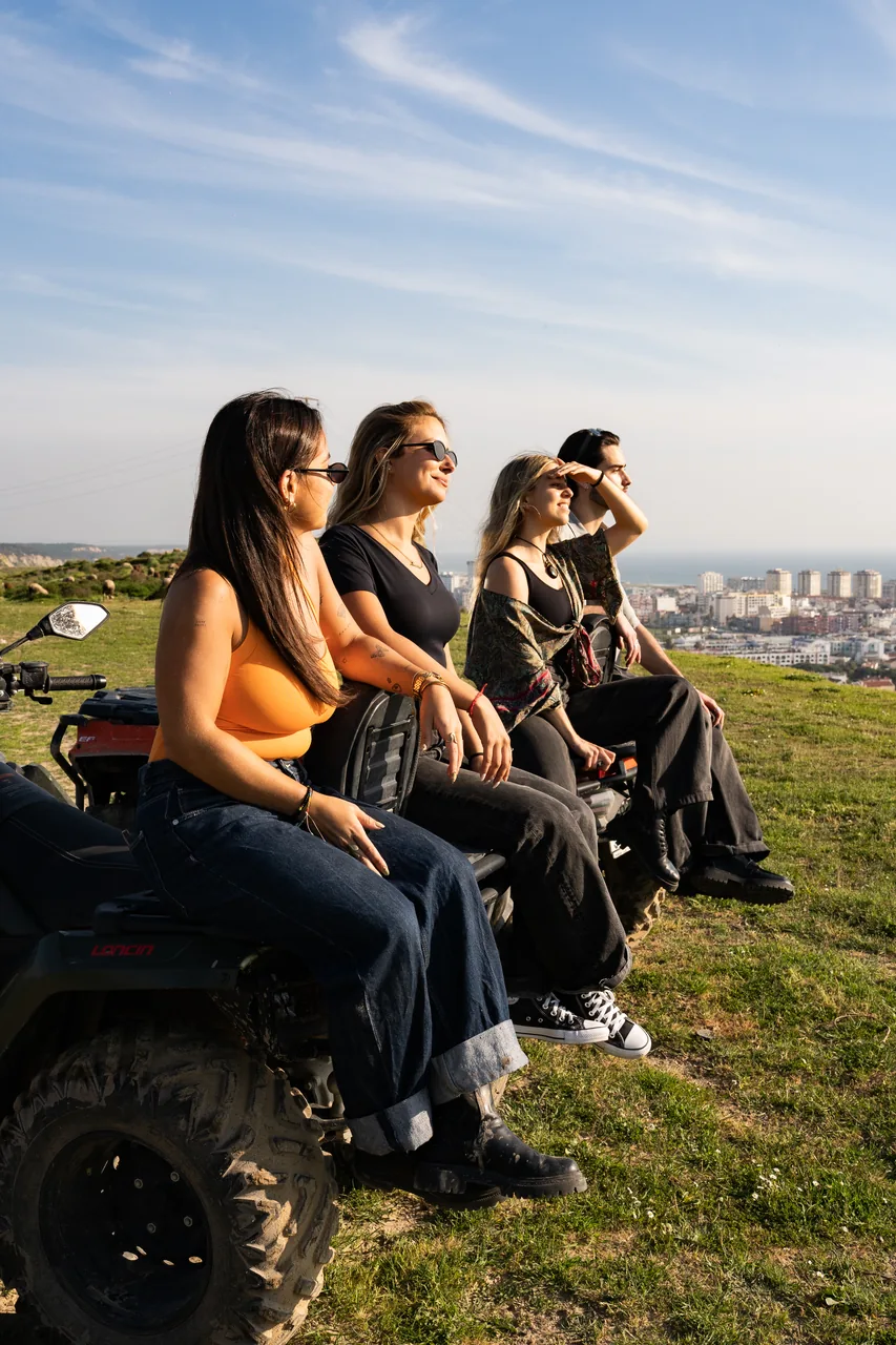 Riders resting on a quad above the Caparica coastline