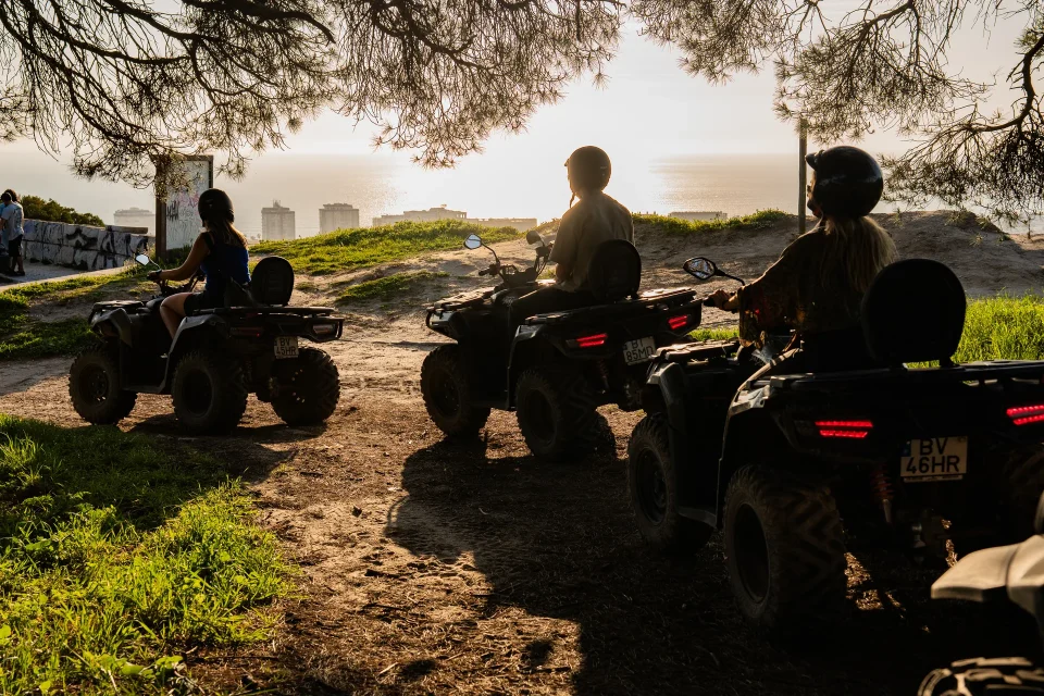 Quads silhouetted along the coast at sunset